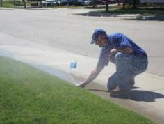 an LA sprinkler repair tech marks a problem sprinkler head